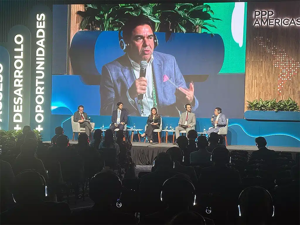 A panel of five sits on stage at a silent conference